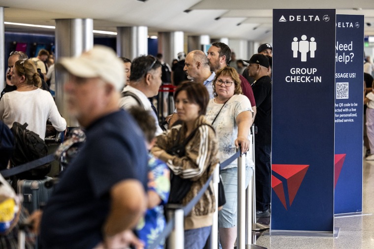 Image: Travelers wait in line at check-in in Terminal 2, Delta Airlines